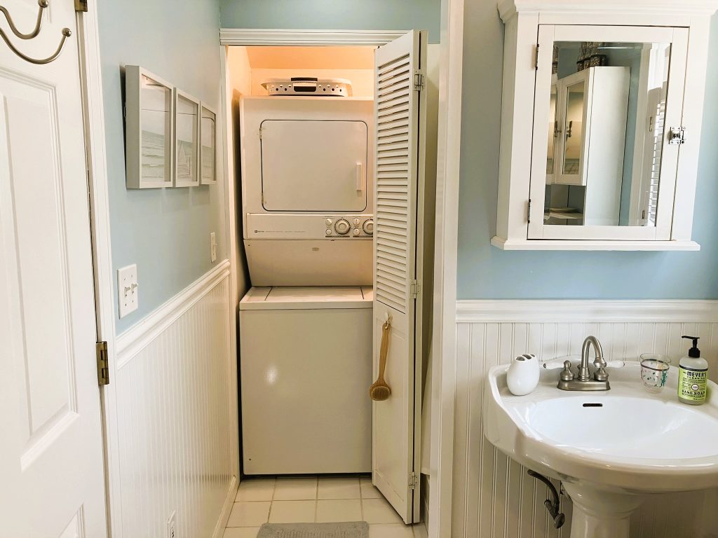 A stackable washer and dryer are located in the bath closet area.