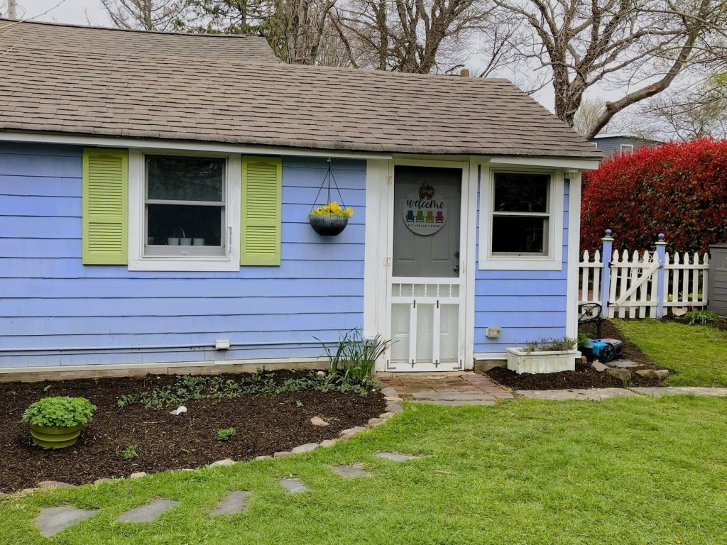 Front view of the bright blue Cape May cottage with lime green shutters